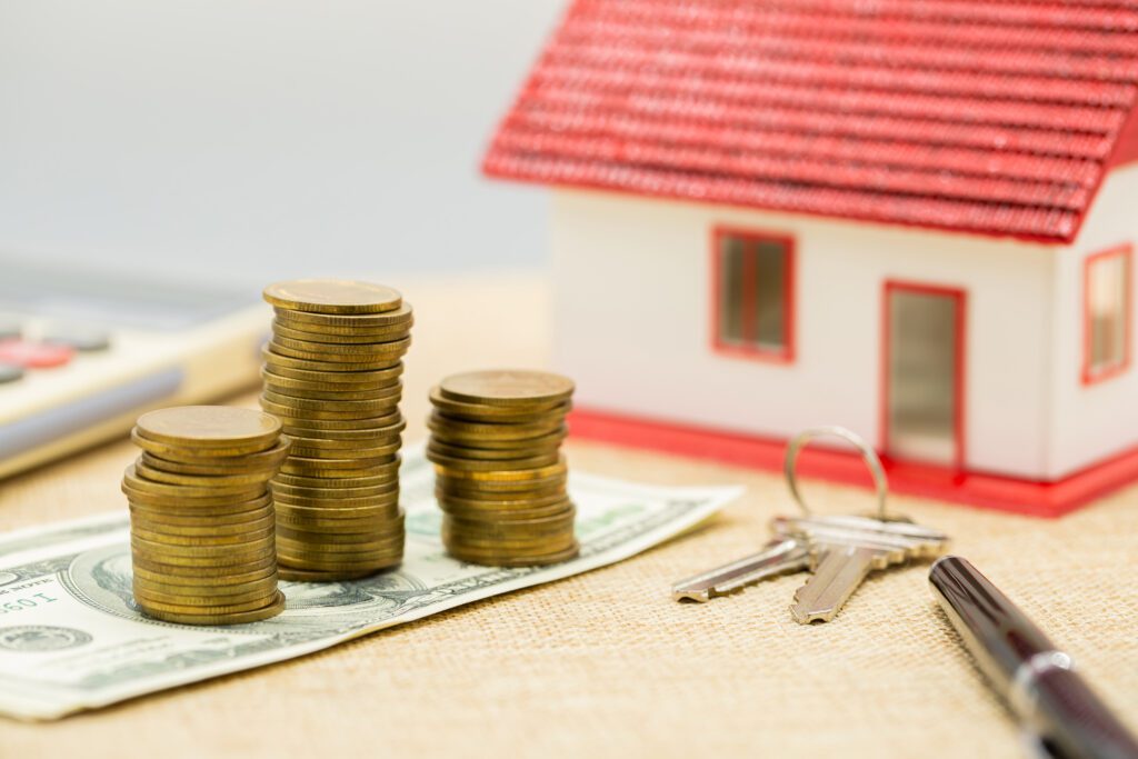 Model house with keys, coins and notes, illustrating property appraisal and home equity.